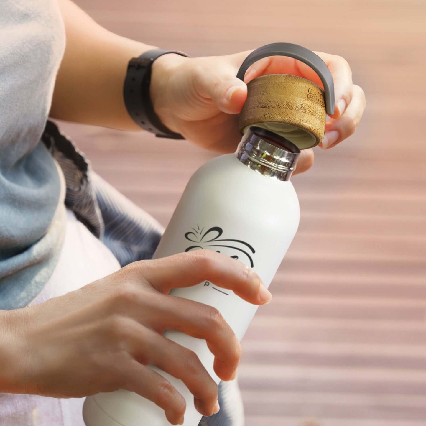 Person holding a Pasadena Steel Bottle with a bamboo lid, perfect for on-the-go hydration and a stylish corporate gift.