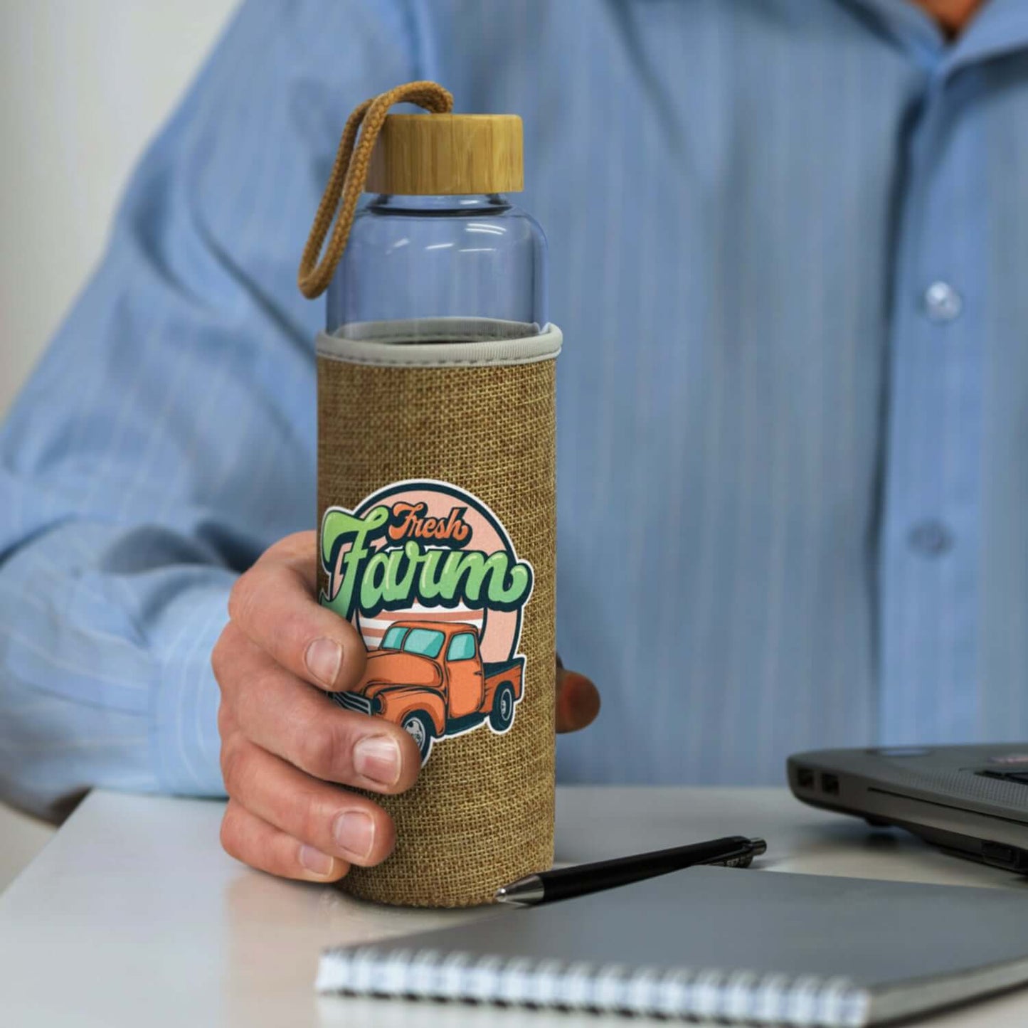 Eden Glass Bottle with Natural Sleeve in hand, stylish hydration solution for corporate gifts.