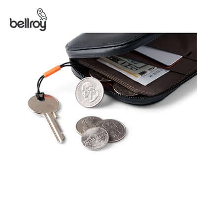 Bellroy All Conditions Phone Pocket Plus Leather open with coins, keys, and cards organized inside.