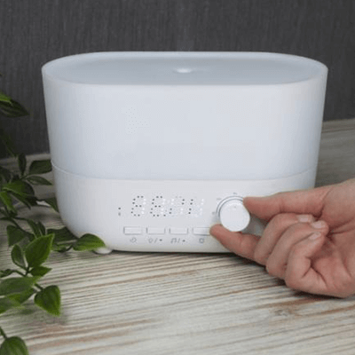 Prixton Connected 4-in-1 Aroma Humidifier with controls and clock display on a wooden table.