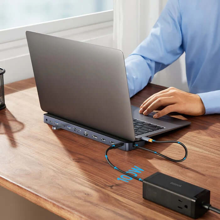 Baseus 12 in 1 Laptop USB-C Hub connected to a laptop on a wooden desk, ideal for corporate gifts.