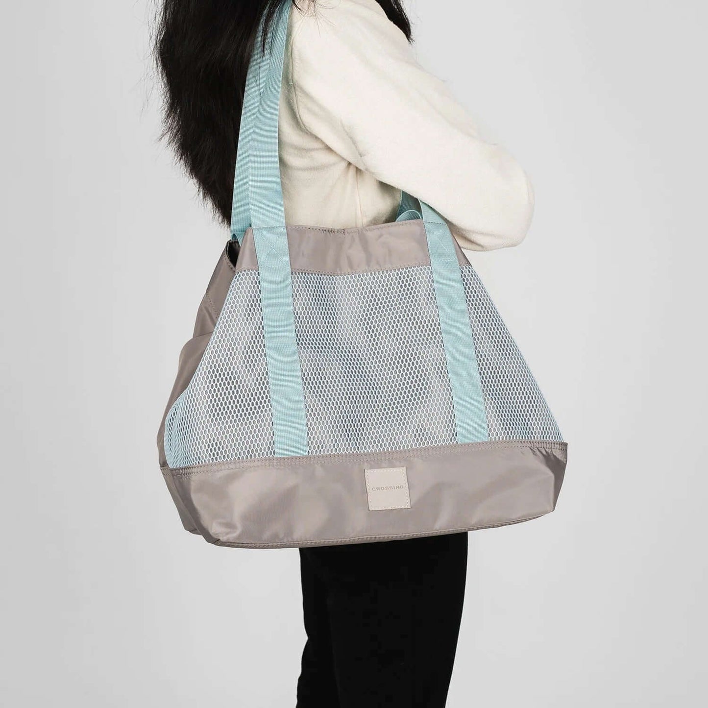Crossing Meg Dual Carry Mesh Tote Bag being held by a woman, showcasing its stylish mesh design and dual handles.