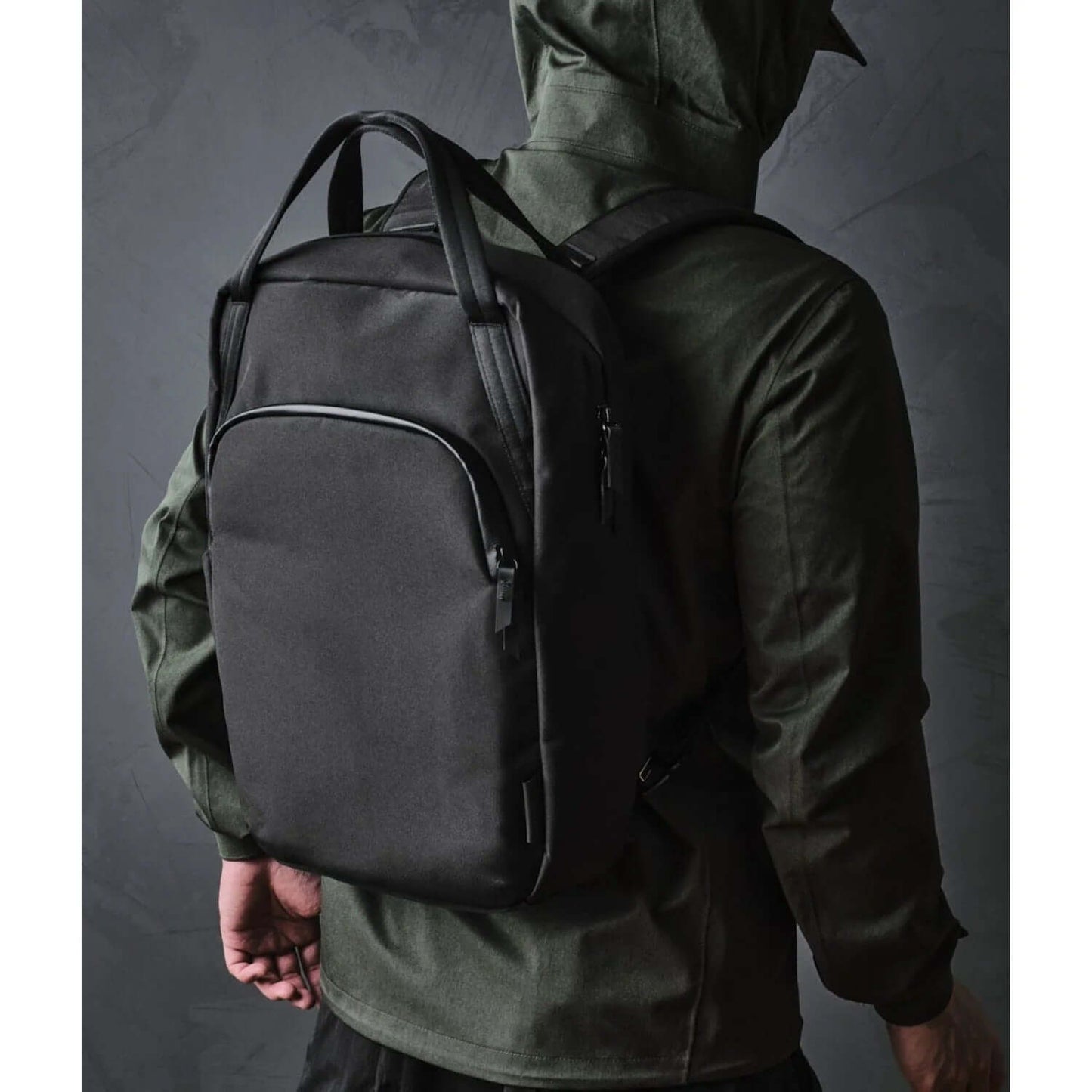 ALPAKA Bravo Tote Pack being worn by a person with a black backpack, showcasing its sleek design and versatility.