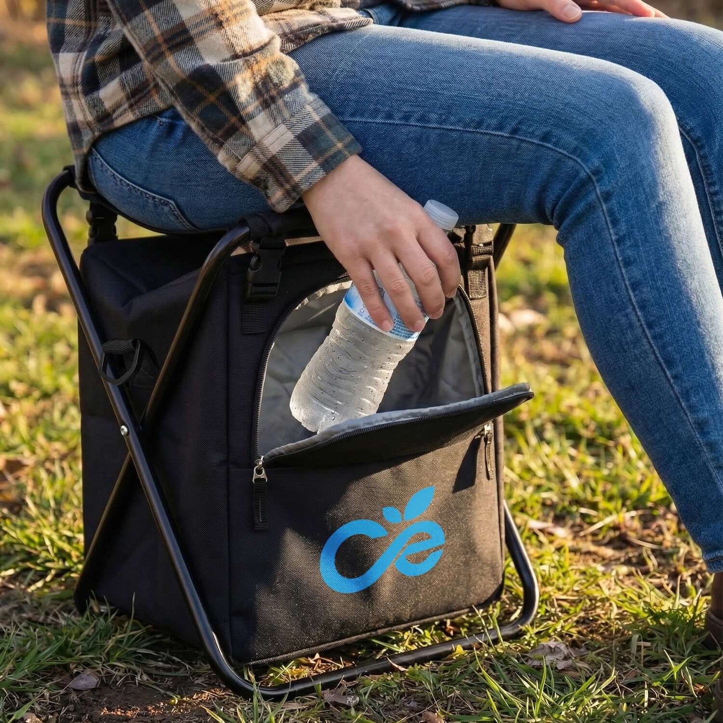 Person using Vermont Cooler Seat with a water bottle in hand, perfect for outdoor adventures and corporate gifts.