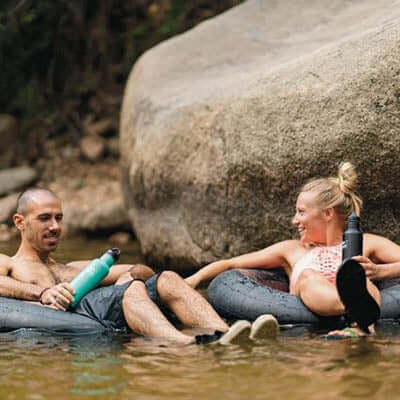 Couple enjoying a relaxing day by the water with Klean Kanteen Insulated Stainless Steel Classic Bottle with Loop Cap.