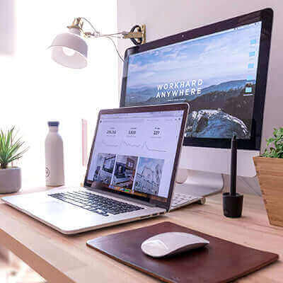 Modern office setup featuring a laptop and desktop computer, representing effective work environments to boost employee morale.