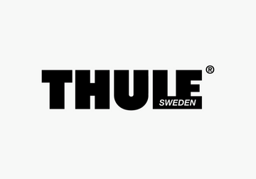 Man using Thule backpack while riding escalator in urban setting, showcasing sleek design and functionality.