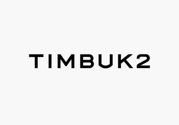 Stylish individual wearing a red messenger bag from the Timbuk2 Bags collection, perfect for city life and corporate gifts.