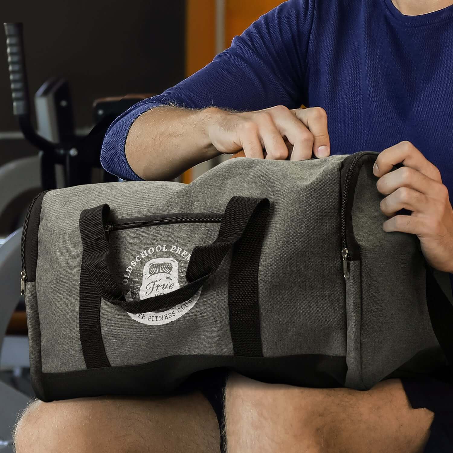 Man opening a Milford Duffle Bag made from durable poly-canvas fabric, ideal for fitness and travel.