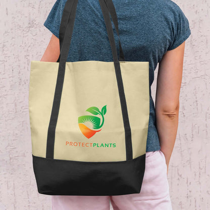 Woman carrying an Armada Tote Bag with a Protect Plants logo, featuring a stylish two-tone design.