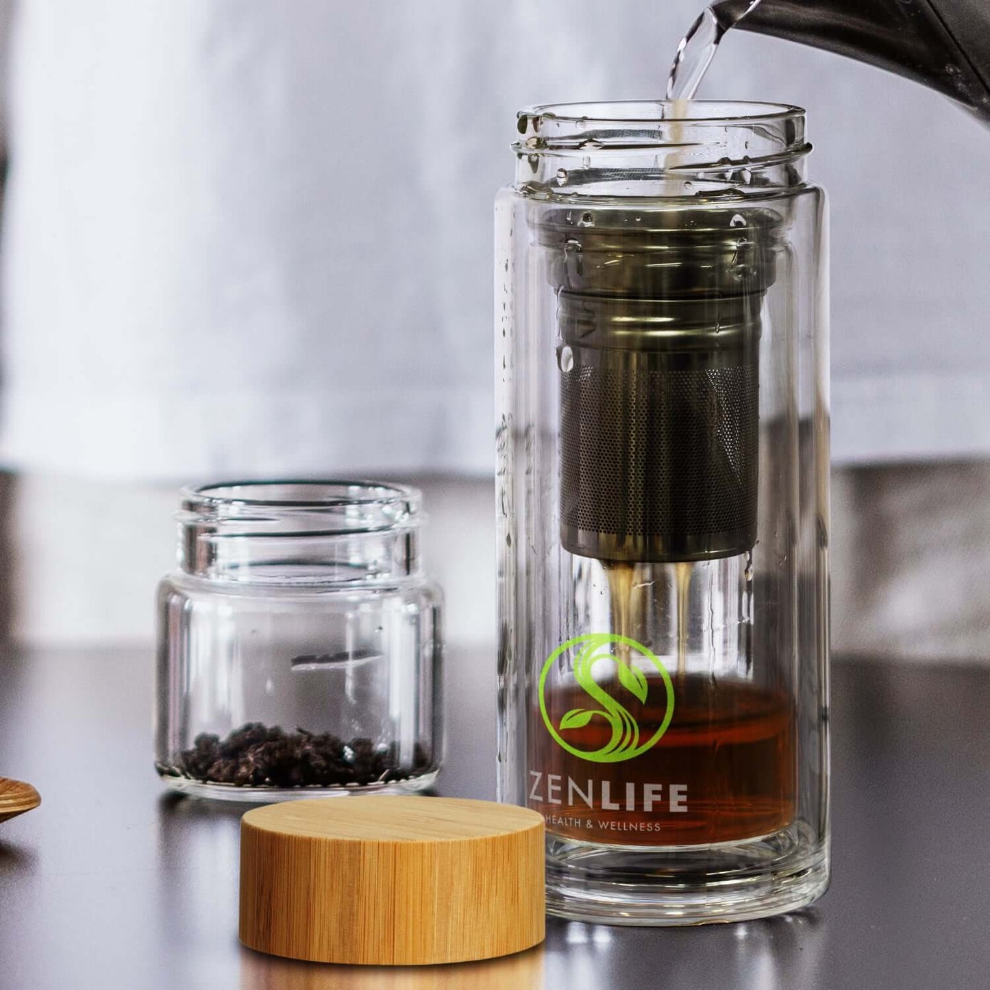 Tea Infuser Bottle being used to brew tea with a bamboo lid and infuser, perfect for corporate gifts.