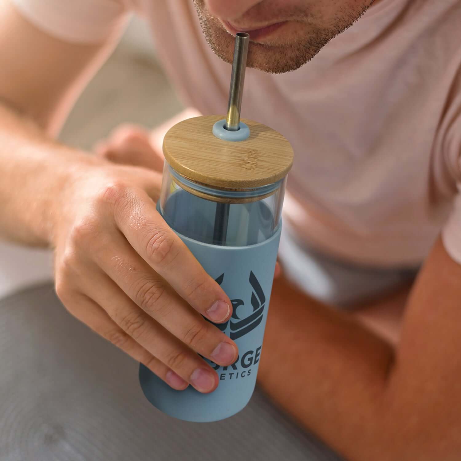 Person using an Alchemy Glass Tumbler with bamboo lid and stainless steel straw.