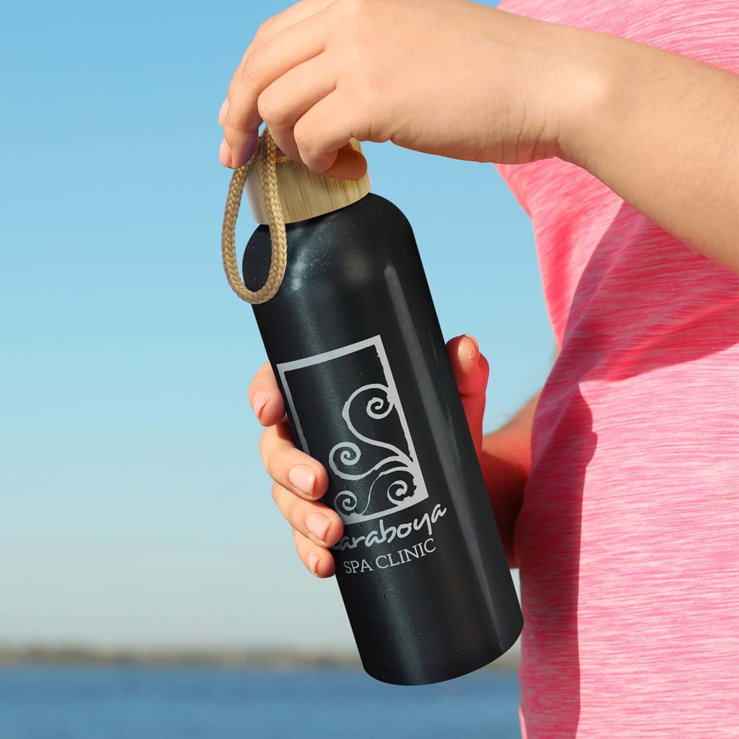 Eden Aluminium Bottle held by a person, eco-friendly design with bamboo lid, perfect as a Corporate Gift.