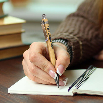 Ancona Bamboo Inkless Pen being used to write in a notebook, perfect for corporate gift ideas.