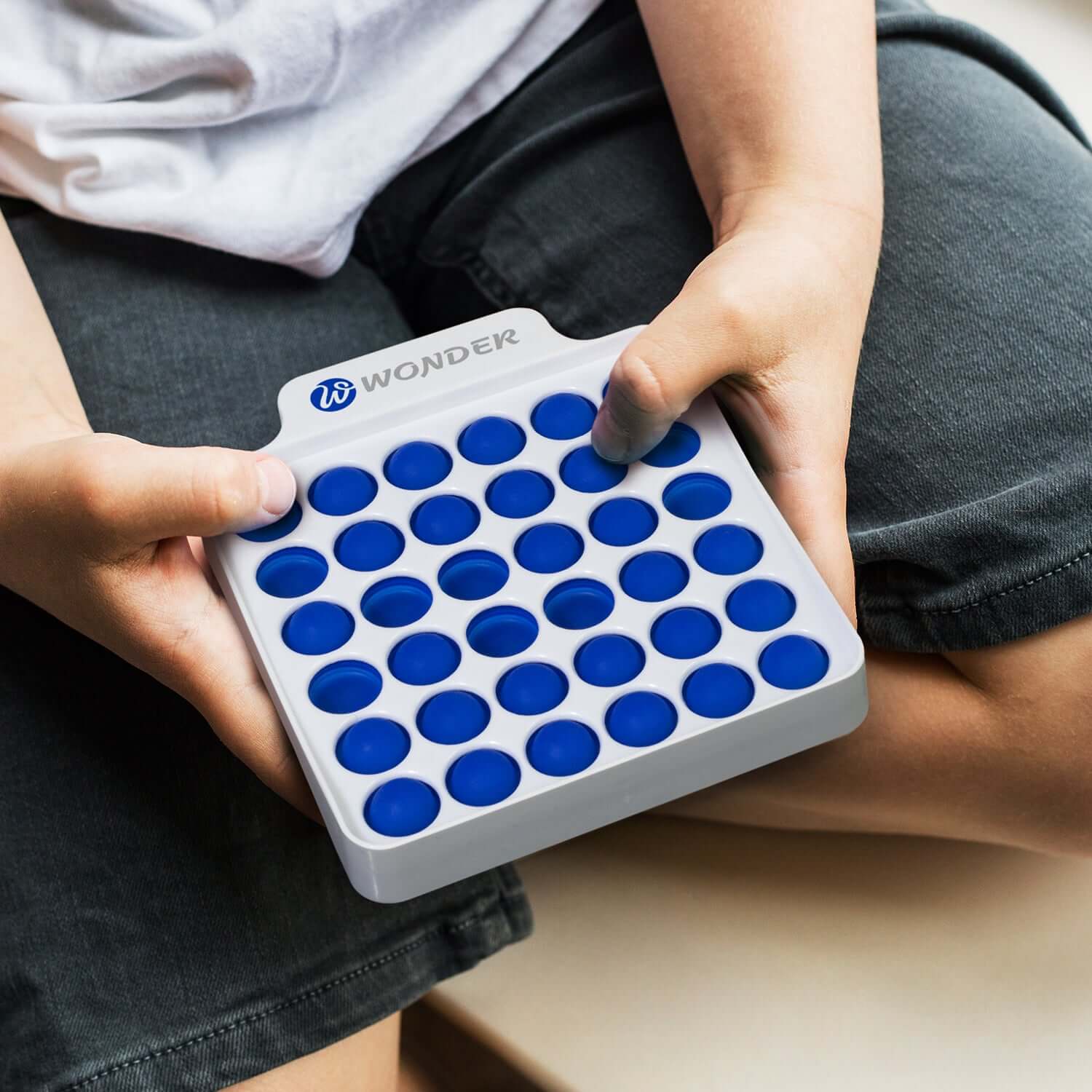 Person holding a Fidget Popper Board Square with blue popping bubbles, perfect for stress relief and corporate gift.