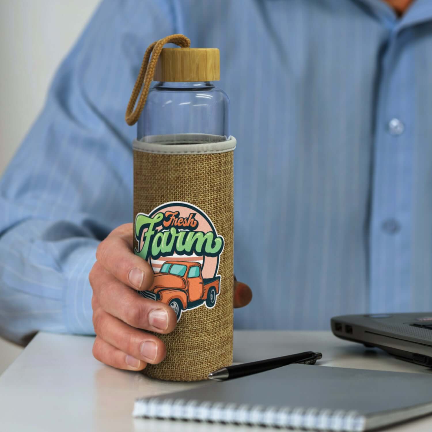 Eden Glass Bottle with Natural Sleeve in hand, stylish hydration solution for corporate gifts.