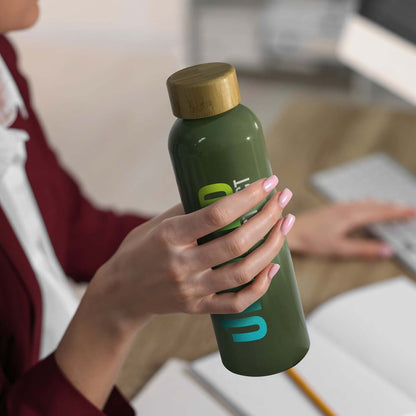 Woman holding Eden Aluminium Bottle Bamboo Lid with bamboo screw-on lid on a desk.