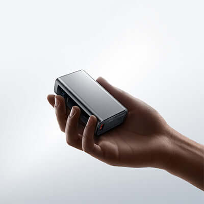 Remax FP-12 Fast Charging Powerbnk 10000mAh held in a hand, showcasing its compact and portable design.