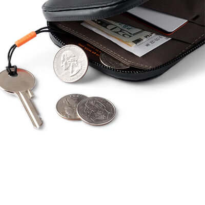 Bellroy All Conditions Phone Pocket Leather showing keys, coins, and cards for versatile everyday use.
