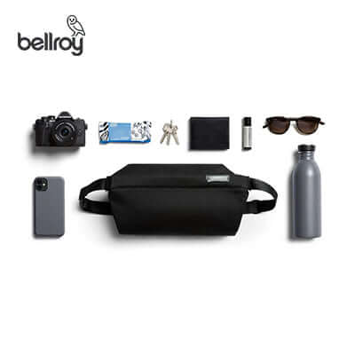Bellroy Sling Bag with essential items including a camera, phone, sunglasses, and a water bottle arranged for corporate gift ideas.