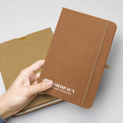 Person holding a Phoenix Recycled Hard Cover Notebook with a textured finish, perfect for corporate gifts.
