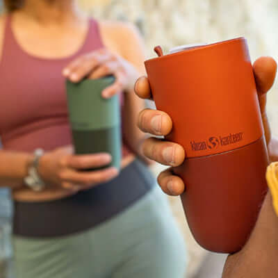 Klean Kanteen Rise 16oz Tumbler (with Flip Lid) held by a person in a sporty outfit, showcasing its earthy design.