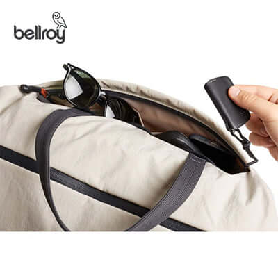 Bellroy Lite Duffel Bag opened with sunglasses and a key clip inside, perfect for a corporate gift.