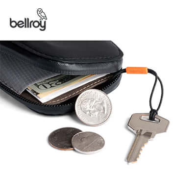 Bellroy All Conditions Card Pocket Leather showcasing coins, bills, and a key in a sleek, functional design.