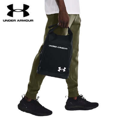 Person carrying Under Armour Contain Shoe Bag, showcasing its practical design for athletes and travelers.