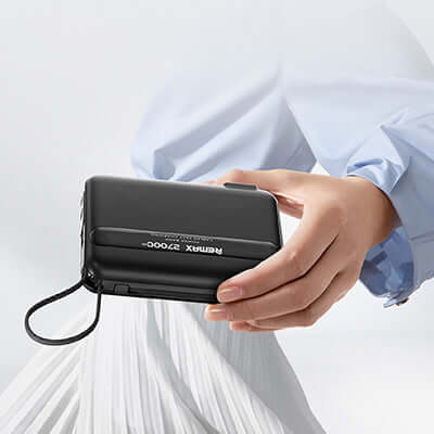 Remax RPP-E7 Fast Charging Powerbank with Wall Plug 27000mAh held in hand, showcasing sleek design and portability.