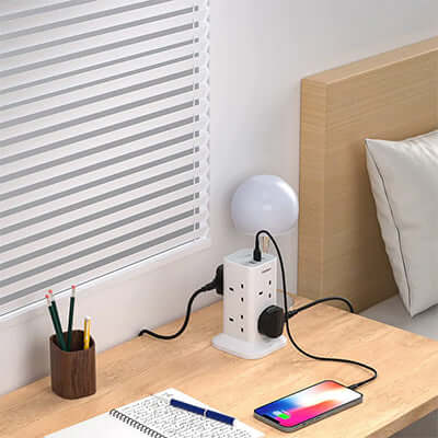 TESSAN Extension Cord Tower 8 Ways with 2 USB-A & 1 USB-C Ports on a bedside table with lamp and phone.