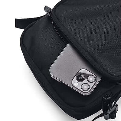 Under Armour Essential Lite Crossbody Bag with iPhone 13 Max Pro in front pocket for easy access.