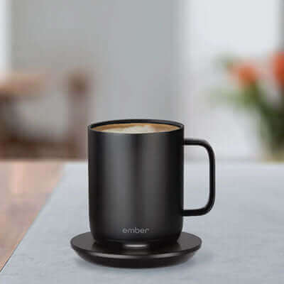 Ember Mug 2 10oz on charging coaster with coffee, ideal corporate gift for coffee lovers.