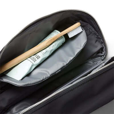 Inside view of Bellroy Toiletry Kit Plus showing toothbrush and toothpaste, ideal for travel and corporate gift.