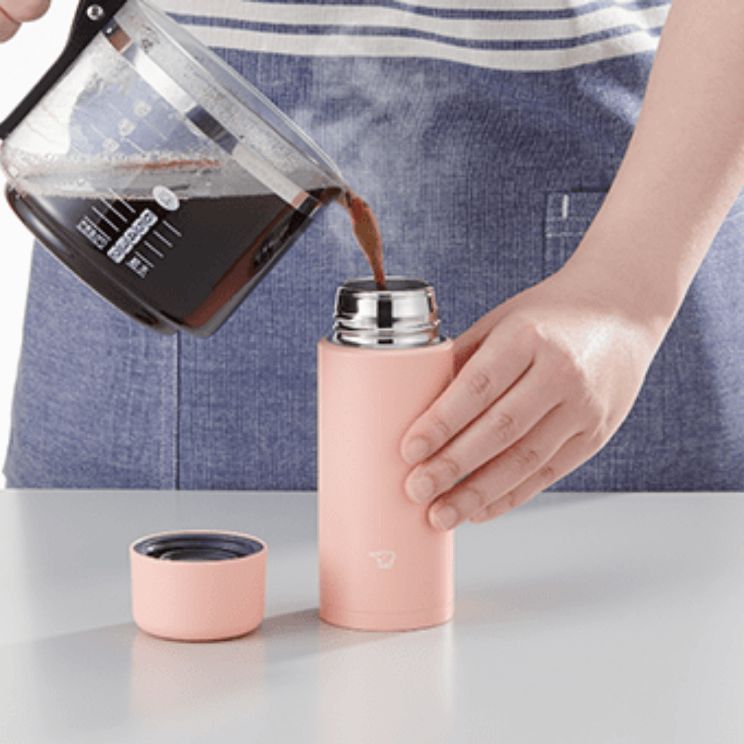 Person pouring coffee into ZOJIRUSHI Stainless Thermal Flask SM-MA on a table, ideal for corporate gift.