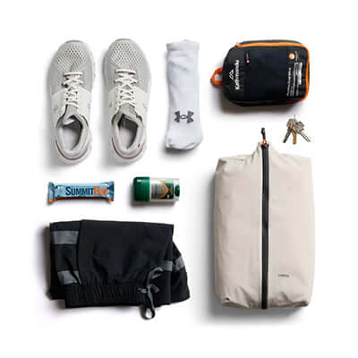 Bellroy Lite Packing Caddy 10L with shoes, gym gear, and snacks organized for travel.