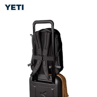 Yeti Ranchero™ 18L Backpack securely fastened to luggage handle, showcasing its travel-friendly design.
