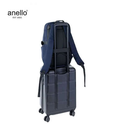 Anello Tie Multifunctional Backpack on top of a suitcase, showcasing its versatility for travel use.