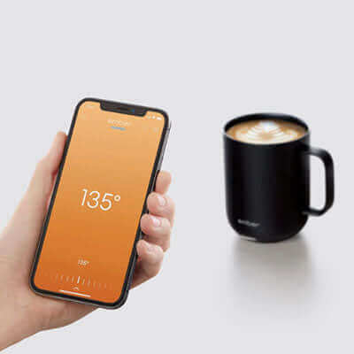 Ember Mug 2 10oz with smartphone displaying temperature for the perfect drink experience.