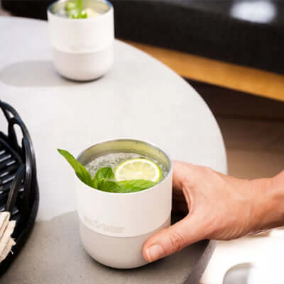 Klean Kanteen Rise 10oz Lowball (with Flip Lid) being used to enjoy a refreshing drink with lime and mint on a table.