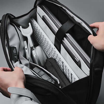 Inside view of the Alpaka Tech Brief Pro 600D Backpack showing organized tech gear and a laptop compartment.