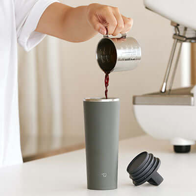 Person pouring coffee into ZOJIRUSHI SX-JA40 0.4L Vacuum Tumbler on a kitchen countertop.