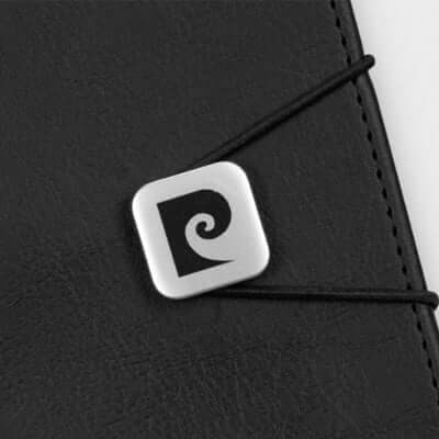 Close-up of the branded metal buckle on the Pierre Cardin Biarritz Notebook, showcasing its elegant design.