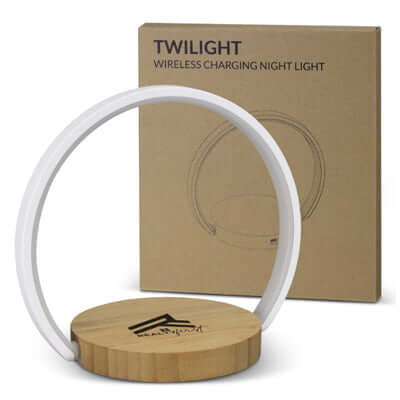 Twilight Wireless Charging Night Light on bamboo base with packaging showing product details.