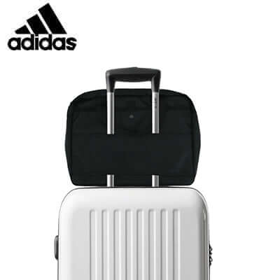adidas Shoulder Bag attached to a rolling suitcase, perfect for travel and corporate gifts.