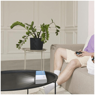 Prixton Mini Pro Cinema Projector on a coffee table, enhancing home entertainment experience with gaming and movies.