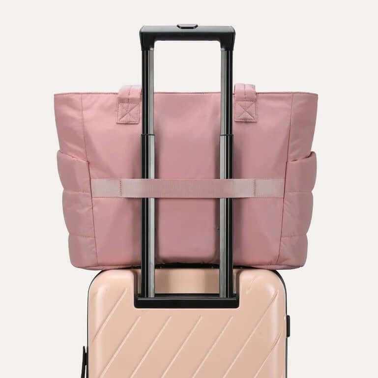 Bagsmart Zora Puffy Tote 20L in pink attached to luggage for travel convenience.