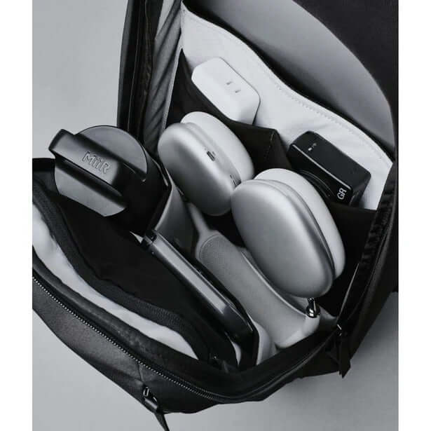 Inside view of ALPAKA Metro Backpack Axoflux 300D showcasing organized tech accessories and a laptop sleeve.