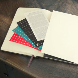 Moleskine 2026 Planner - Weekly with colorful inserts on a wooden surface, ideal for organization.