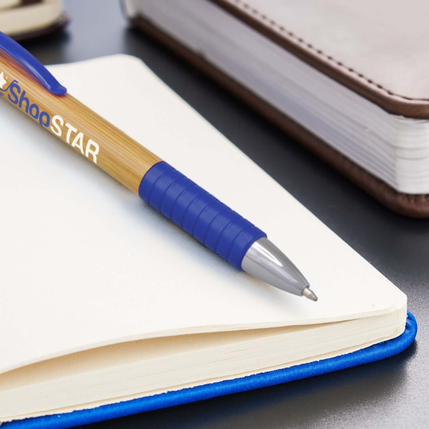 Trinity Bamboo Pen on a notebook, showcasing its bamboo design and retractable ballpoint mechanism.